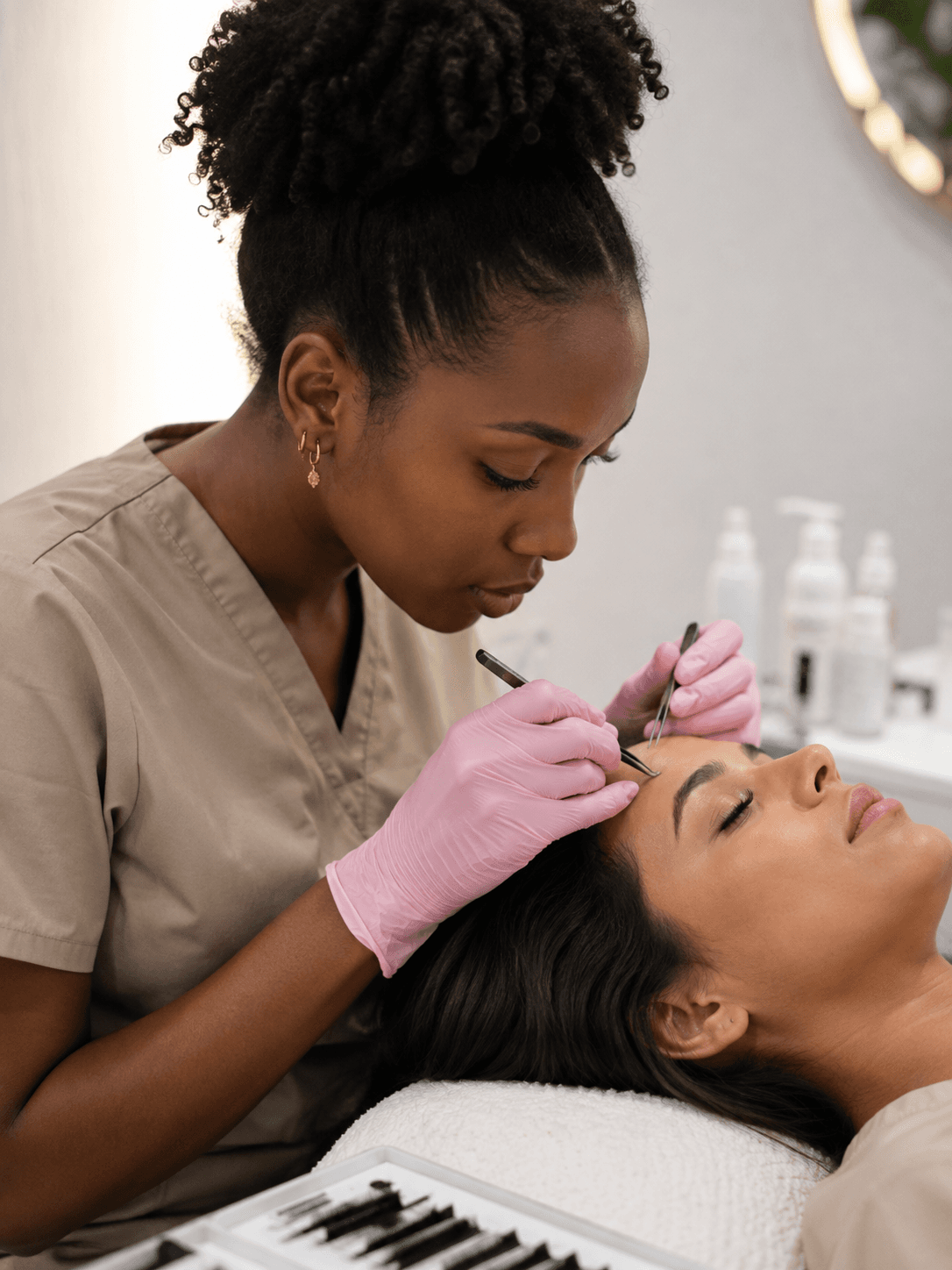 Profissional realizando extensão de cílios em uma cliente
