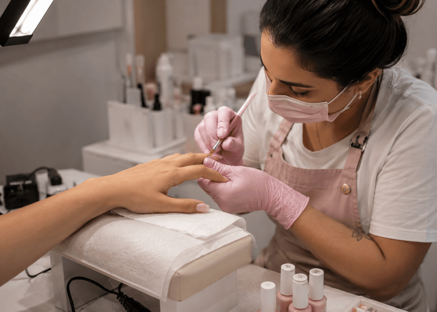 Profissional realizando esmaltação nas unhas de uma cliente